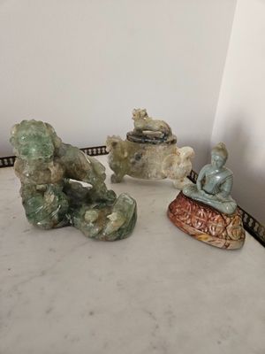 three figurines sitting on a table next to each other