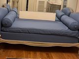 a blue couch in a living room with a mirror on the wall