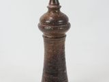 a small wooden pepper mill on a white surface