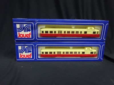 two boxes of toy trains sitting on top of a black surface