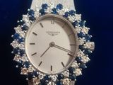 an image of a close up of a wrist watch with blue and white stones