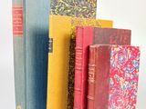 plusieurs livres sont alignés sur une surface blanche