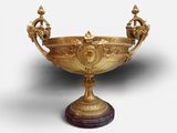 a gold bowl on a wooden stand on a white background