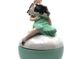 une figurine représentant une femme assise sur une boîte
