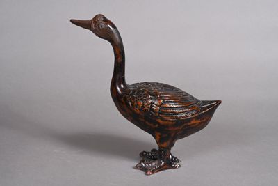 a small wooden duck that is sitting on a table