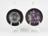 pair of black and white plates with purple designs on them
