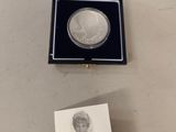 a silver coin with a picture of a woman in it