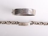 deux bracelets en argent et une bague en argent posés sur une surface blanche