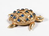 une broche en forme de tortue en or, ornée de pierres bleues