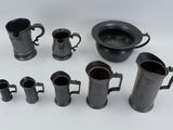 many different types of black pitchers and cups on the table