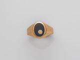 a gold ring with a black stone and a diamond