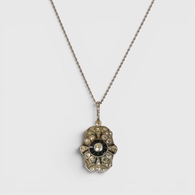 a close up of a necklace with a flower on it