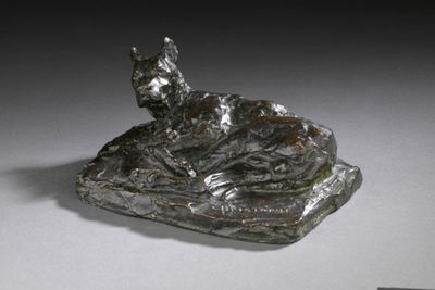 statue d'un chat allongé sur un rocher, posée sur un fond blanc