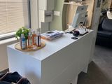 un bureau blanc sur lequel se trouvent un ordinateur portable et un sac