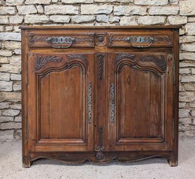 an old wooden cabinet sitting against a stone wall in front of a brick wall