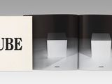 an open book with a black and white image of a cube