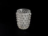 a clear glass vase with bubbles on it on a black surface