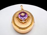 an image of a gold locke with a purple stone in the center