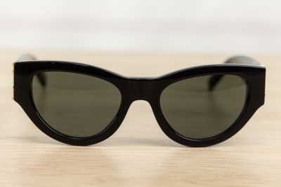 une paire de lunettes de soleil noires posée sur une table en bois