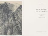 an open book with a drawing of a mountain in the background