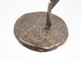 a bronze statue of a man holding a baseball bat on top of a coin
