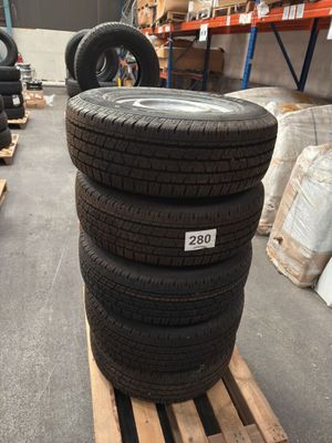 several tires stacked on pallets in a warehouse with pallets of other tires