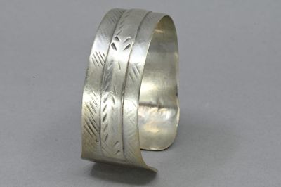 silver cuff bracelet with engraved design on the inside