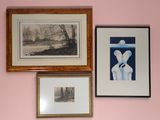trois tableaux encadrés accrochés au mur au-dessus d'un lit