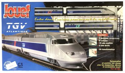 circuit de trains miniatures représentant un train argenté et bleu dans une gare