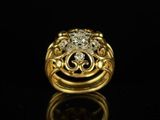 a close up of a gold and diamond ring on a black surface