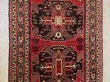 un gros plan d'un tapis rouge et noir accroché au mur