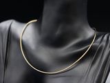 un gros plan sur le torse d'un mannequin portant un collier en or