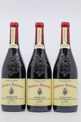 trois bouteilles de vin rouge posées l'une à côté de l'autre sur une surface blanche