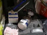 a suitcase filled with items that include a propanent and a gas can