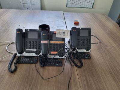 three phones sitting on a table with a cup of coffee