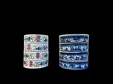 three blue and white cups with oriental designs on them on a black background