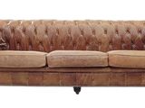 canapé en cuir marron avec accoudoirs et pieds capitonnés