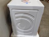 a white washing machine sitting on a pallet in a warehouse