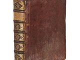 an old book with a brown cover sitting on top of a white surface