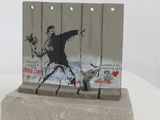 a sculpture of a man holding a flower on a cement block
