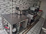 plan de travail en acier inoxydable dans une cuisine commerciale avec des casseroles et des poêles dessus