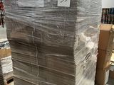 une grande pile de cartons dans un entrepôt, sur laquelle est apposée une étiquette de prix