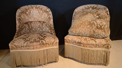 two chairs with fringes on them sitting on the floor