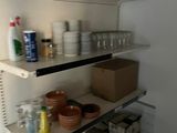 many dishes and cups on the shelves in the kitchen