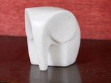une figurine d'éléphant blanc posée sur une table en bois