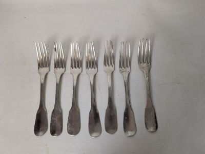 six forks that are sitting next to each other on a table