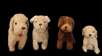 quatre chiens en peluche sont alignés sur une rangée devant un fond noir