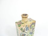 a small vase that has a flower design on it