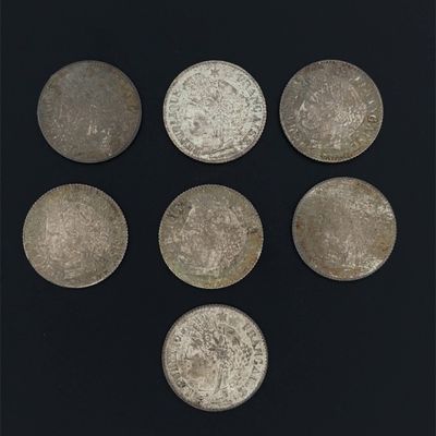 six silver coins are arranged in a circle on a black surface
