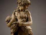 statue of a woman holding a baby and a bird in her arms